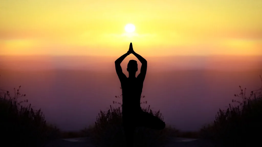 homme pratiquant yoga plage coucher soleil